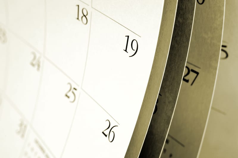 A blank calendar at an artistic angle, with a close-up on the right edge of the calendar, but with months of pages visible tucked behind.